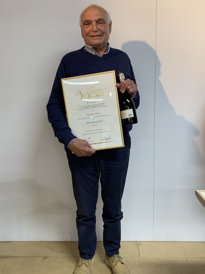 Rainer Zott mit seiner gerahmten Ehrenmitgliedsurkunde.