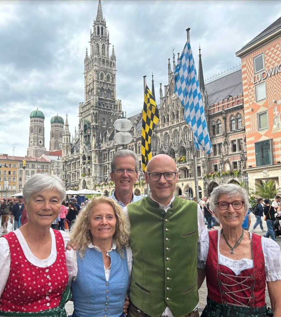 5 Gudies in bayerischer Tracht stehen vor dem Rathaus am Marienplatz.