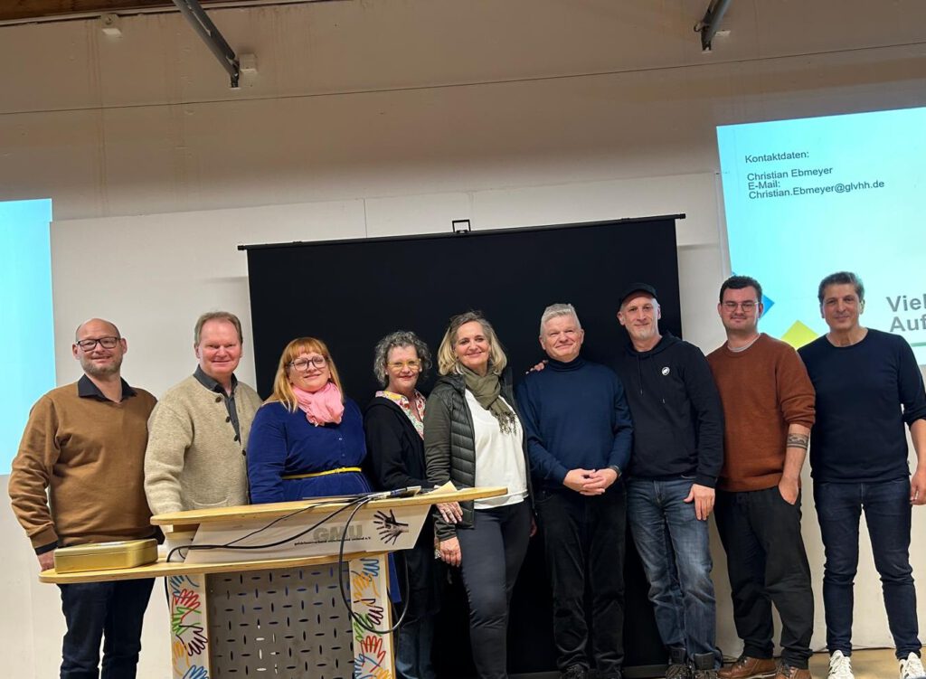 Der Vorstand von GMU und vom KOGEBA sowie vom Landesverband Bayern der Gehörlosen e.V. stehen auf der Bühne zusammen mit Christian Ebmeyer